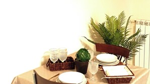 Una mesa de comedor dispuesta con platos, vasos y una planta.