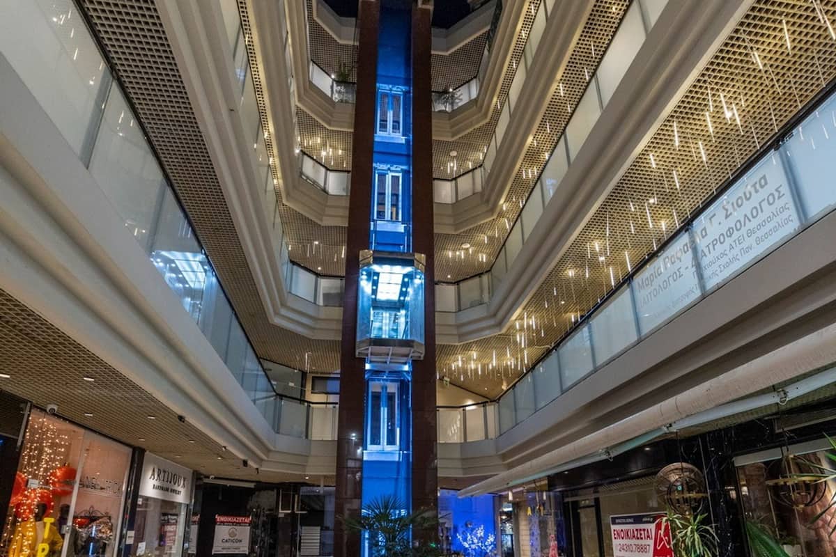 A multi-level atrium with modern architecture, glass railings, and illuminated signage.