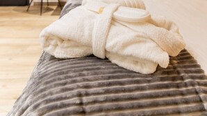 Una camera d'albergo con un letto, una sedia, una scrivania e un condizionatore d'aria.