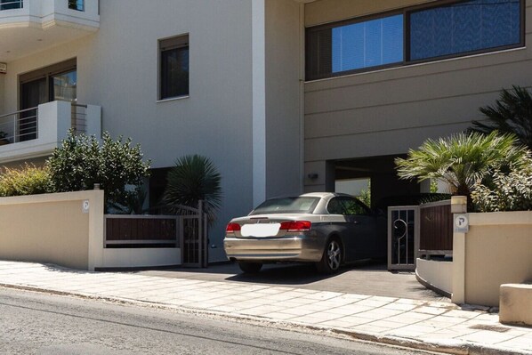 A modern two-story building with a car parked in the driveway.