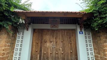 Una puerta de madera tradicional con un letrero encima que dice "DUONG LAM HOSTEL & CAFE".