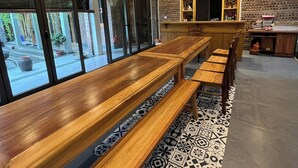 Un intérieur moderne avec des bancs en bois, des carreaux de sol à motifs et des lampes en osier suspendues au plafond.