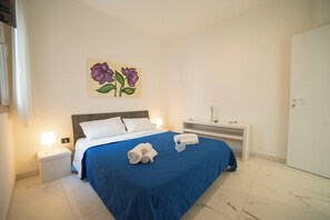 Une chambre d’hôtel comprenant un lit, une table de chevet, une commode, une œuvre d’art murale et une armoire.
