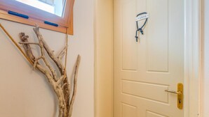 A white door with a brass handle and a nameplate reading "PAXOS." - Paxi Apt in Gaios With 1 Bedrooms and 1 Bathrooms (Paxos)