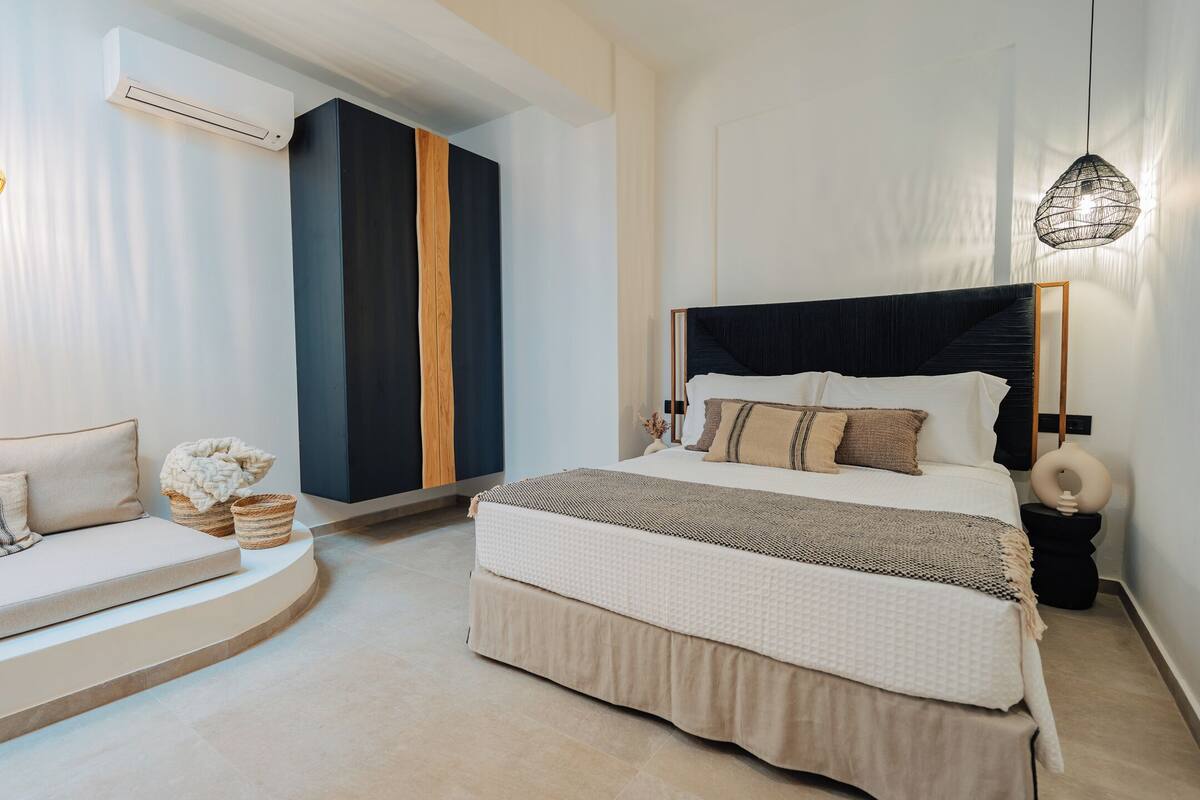 A modern bedroom with a bed, a sofa, and a built-in wardrobe.