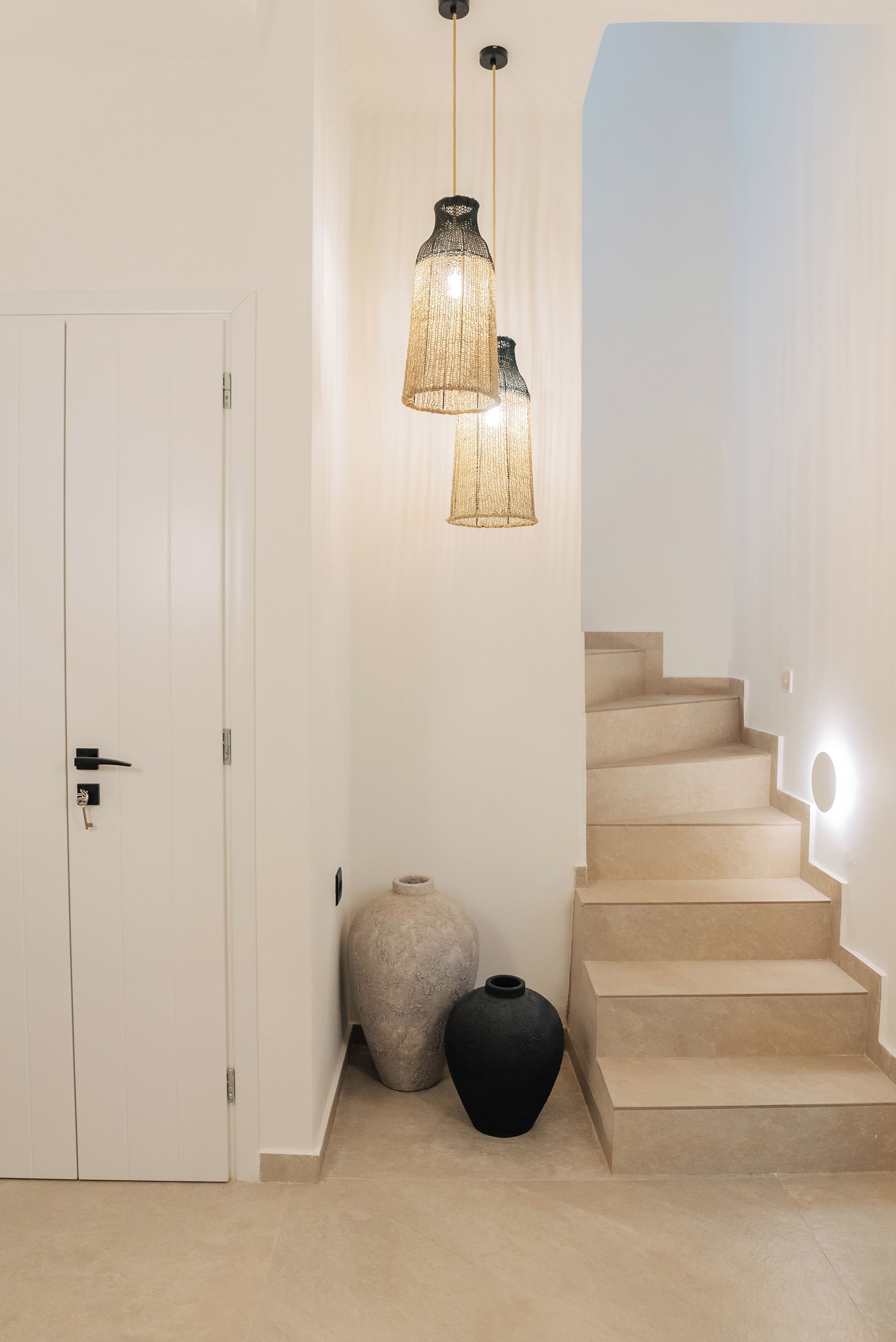 Una escalera con escalones color beige y una puerta blanca.