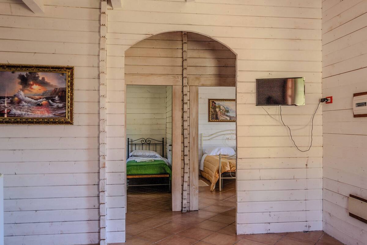A room with a bed, a television, and a painting on the wall.