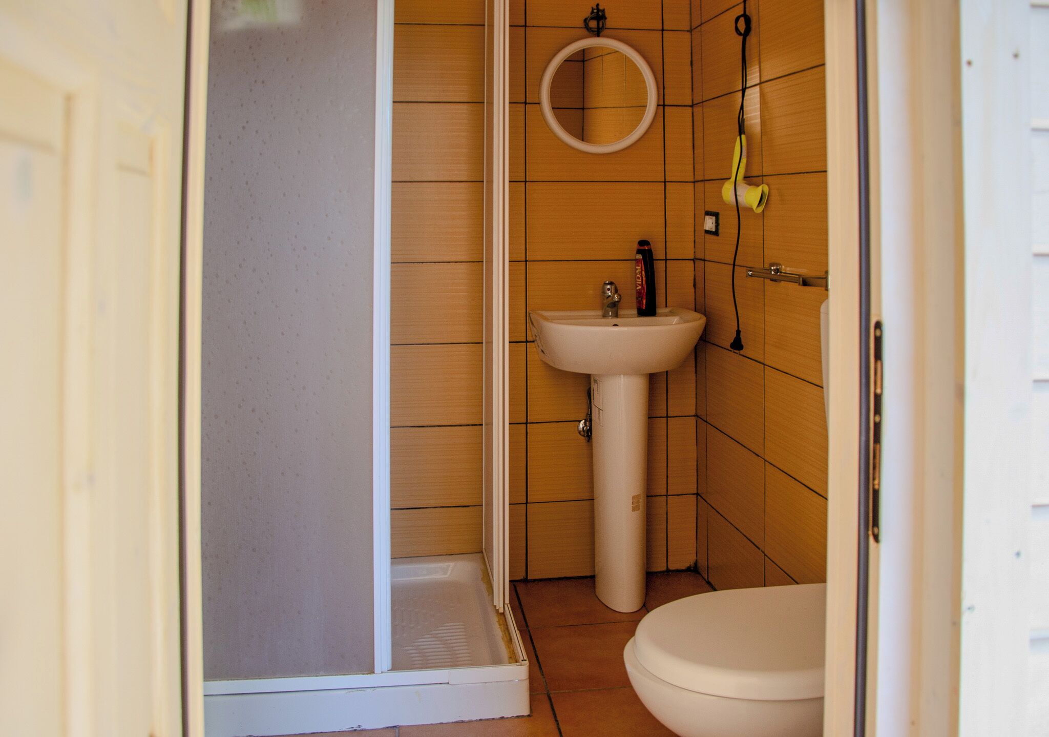 A bathroom with a shower, sink, and toilet.