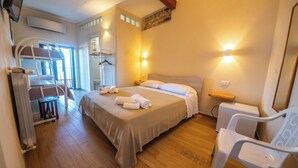 A well-lit bedroom with a large bed, bedside tables, a chair, and a wardrobe.