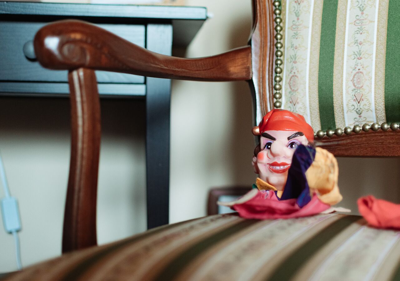 A wooden chair with a striped cushion and a decorative pillow.