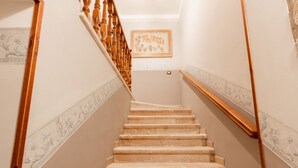 En trappa med träräcken och trappsteg klädda med beige matta.