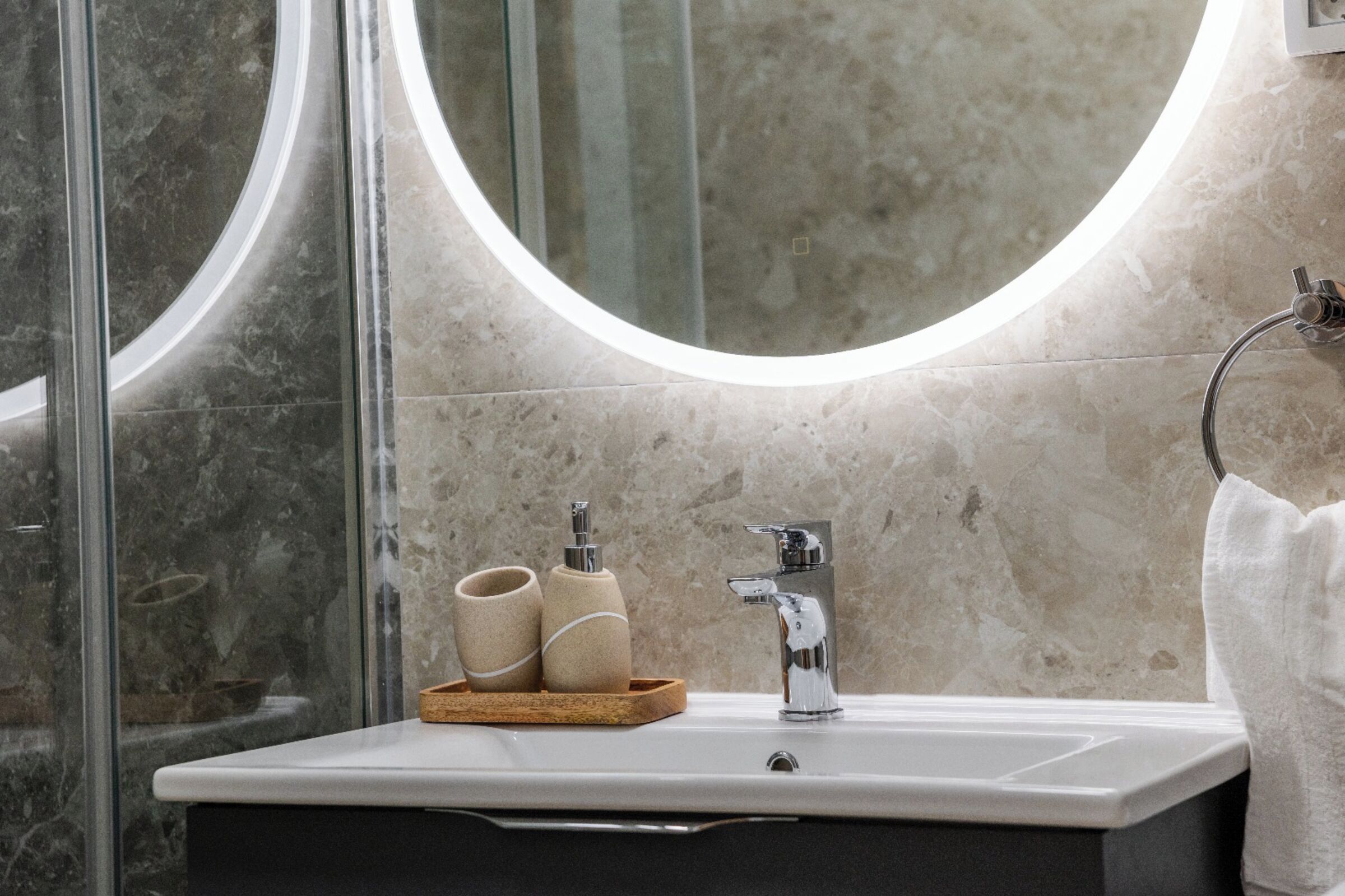 Un baño moderno con un espejo grande, un lavabo y un perchero para toallas.