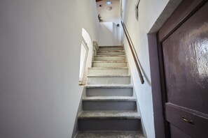 A staircase with a handrail, a door, and a window at the top.