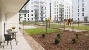 A balcony with a view of a playground and apartment buildings.