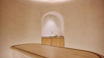 Clean lines and minimalist design define this bathroom, featuring a curved vanity and gold faucet.
