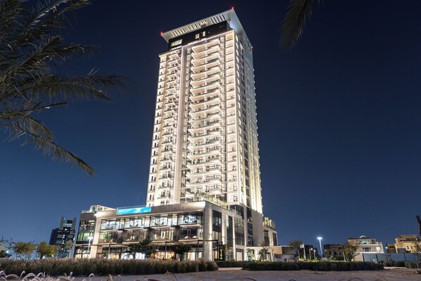 A high-rise building with multiple balconies and a modern architectural design. - The OQ (Lusail)