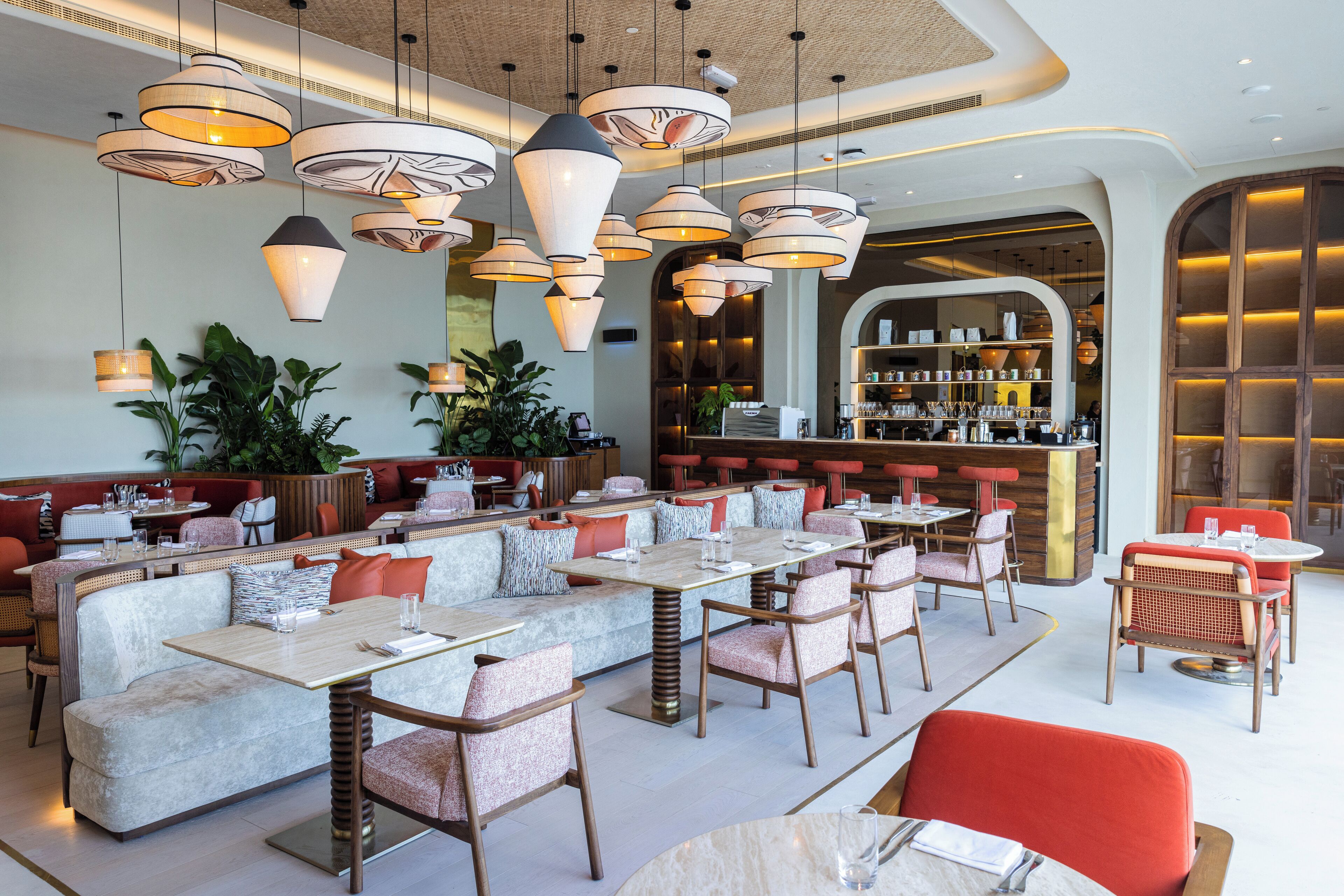 A restaurant with multiple seating areas, including booths and tables, and a bar area with shelves of bottles and glasses.