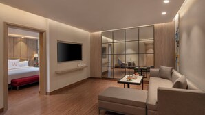 A modern hotel room with a bed, a sofa, a TV, and a dining area. - Welcomhotel By ITC Hotels Delhi-Gurugram Highway (Gurugram)