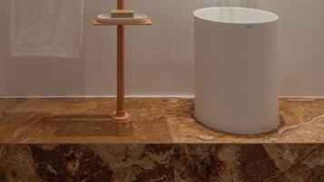 A bathroom with a round mirror, a towel rack, a sink, and a soap dish.