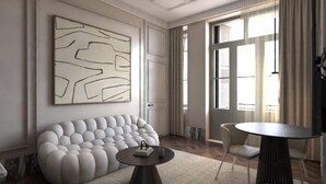 Un salon moderne avec un canapé capitonné, une table basse ronde et un grand tableau abstrait accroché au mur.