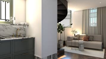 A modern kitchen with marble countertops and a built-in sink, a living area with a sofa and a coffee table, and a staircase leading to an upper level.