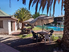 A pool area with a covered seating area, outdoor tables, and chairs. - Cabañas Yunkai (Vicuña)