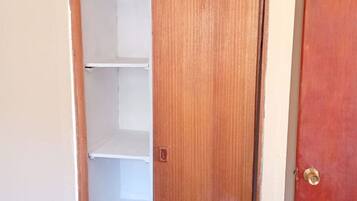A wooden door with a white shelf unit inside.