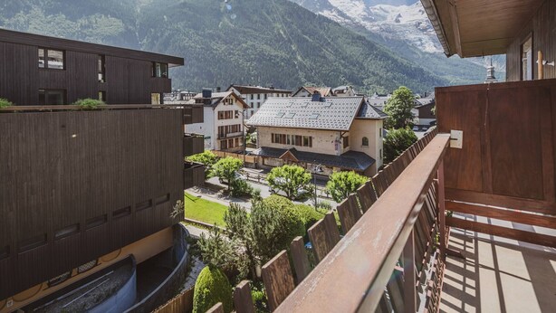 A wooden building with a balcony overlooking a town and mountains. - 3P Apartment Chamonix, Close to Slopes, Pets Allowed, Parking, WiFi (Chamonix-Mont-Blanc)