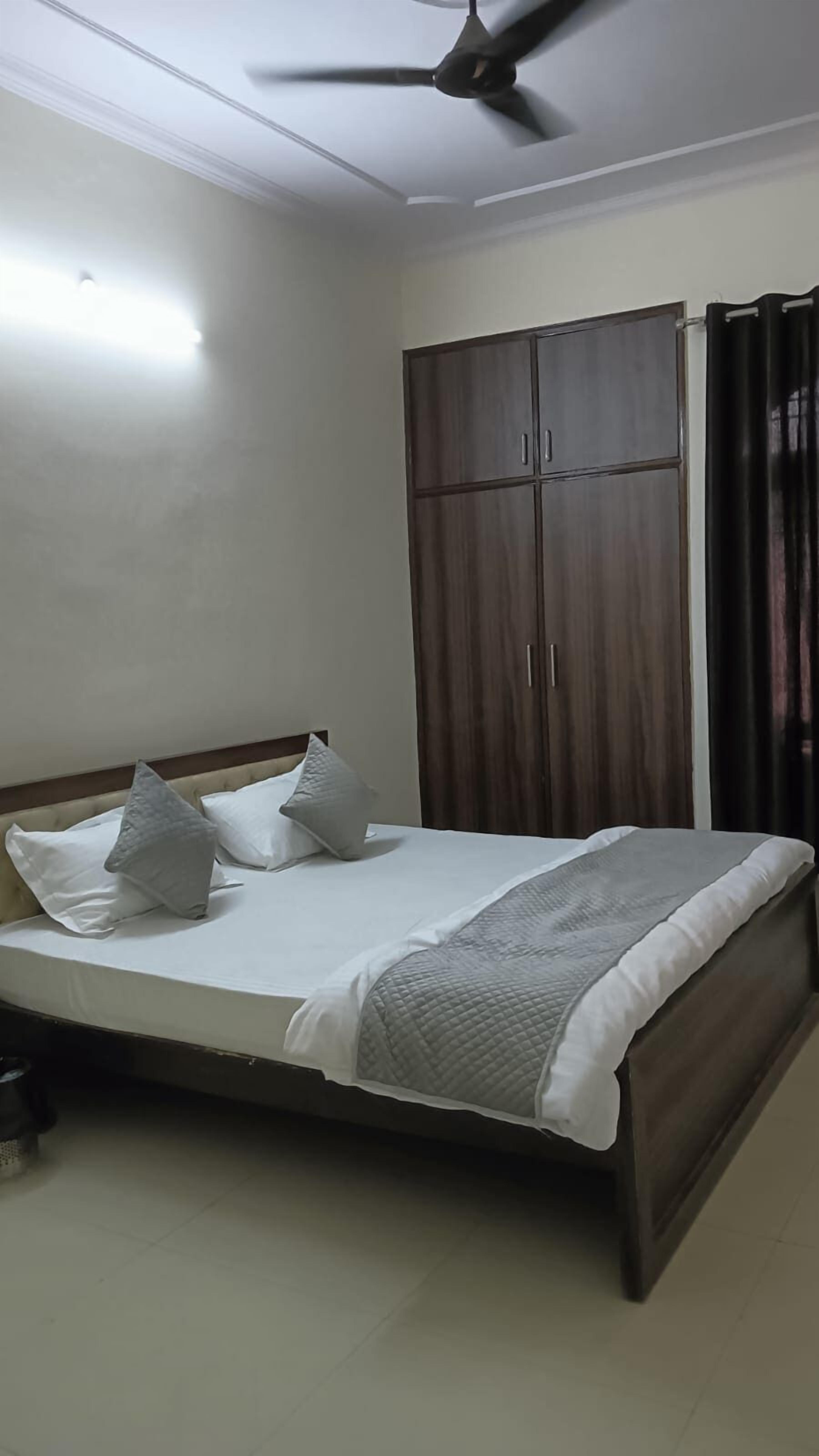 A bedroom with a bed, a wardrobe, and a ceiling fan.