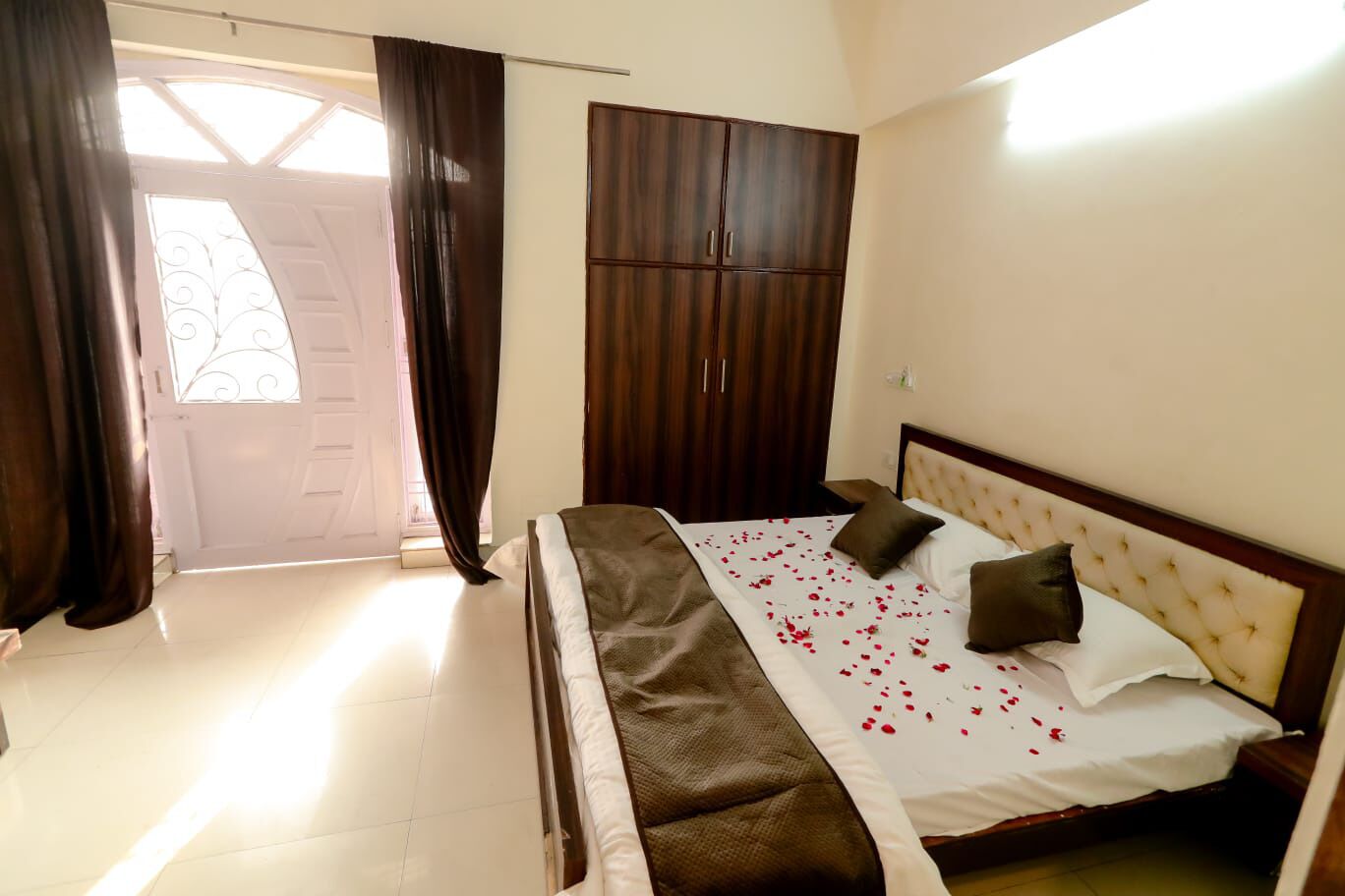 A bedroom with a bed, a wardrobe, and a door with curtains.