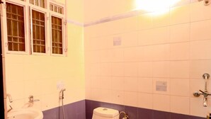 Une salle de bain avec des toilettes, un lavabo et une douche.