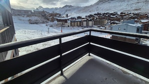Un paese montano innevato con edifici e cielo sereno.