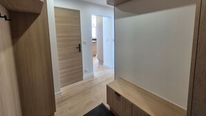 Un corridoio moderno con pavimento in legno e scaffali a muro.
