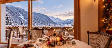 Mesa para dos personas con vistas a montañas nevadas.