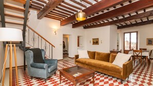 Un espai saló ampli amb sostre de fusta, un sofà, una taula de centre i un paviment amb disseny.
