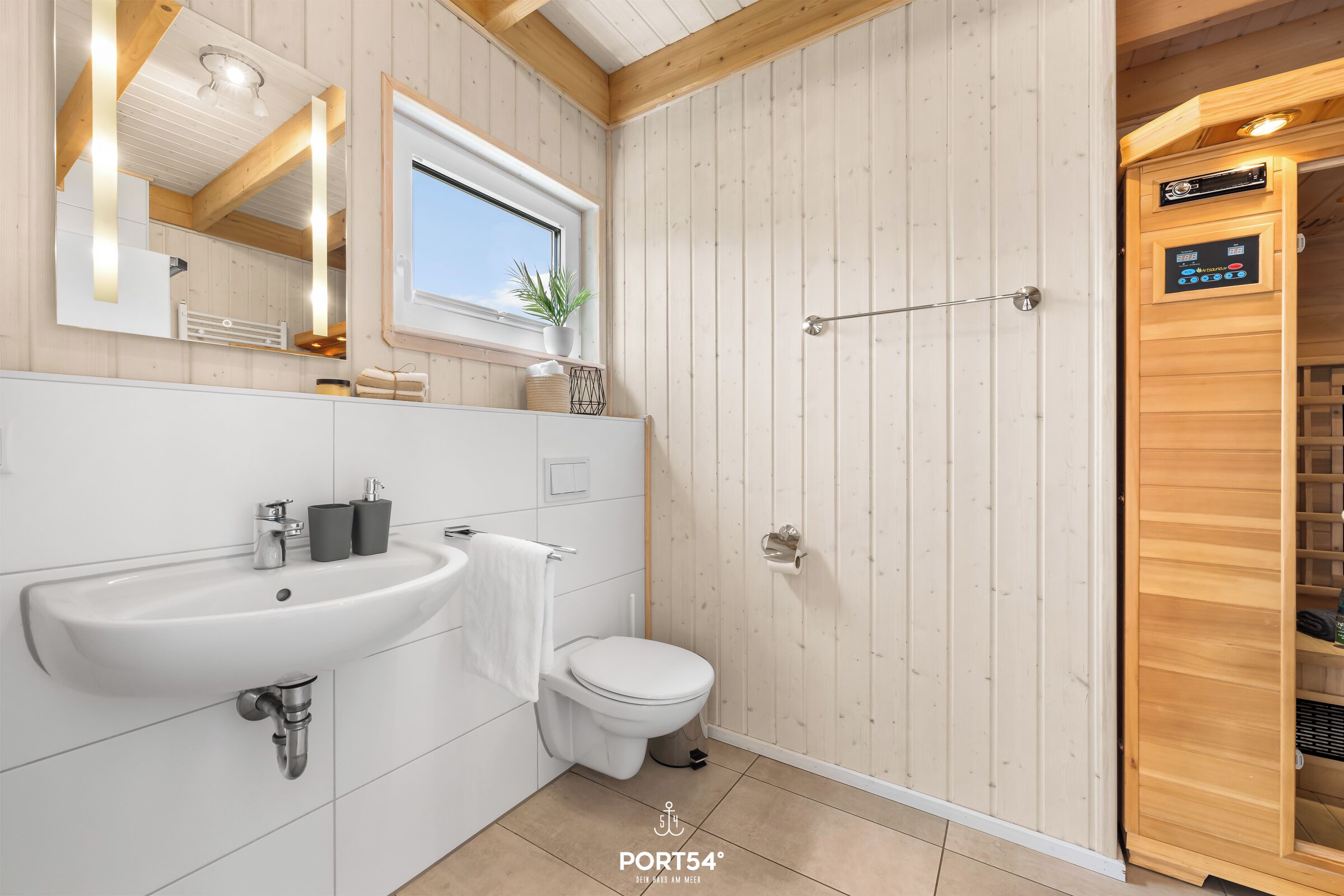 A modern bathroom with a white sink, toilet, and wooden panel walls.