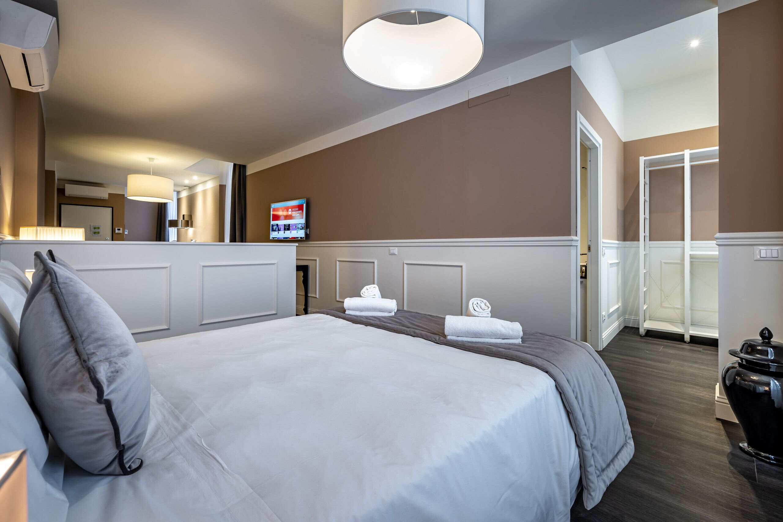 A hotel room with a large bed, a television, and a bathroom with a shower and toilet.