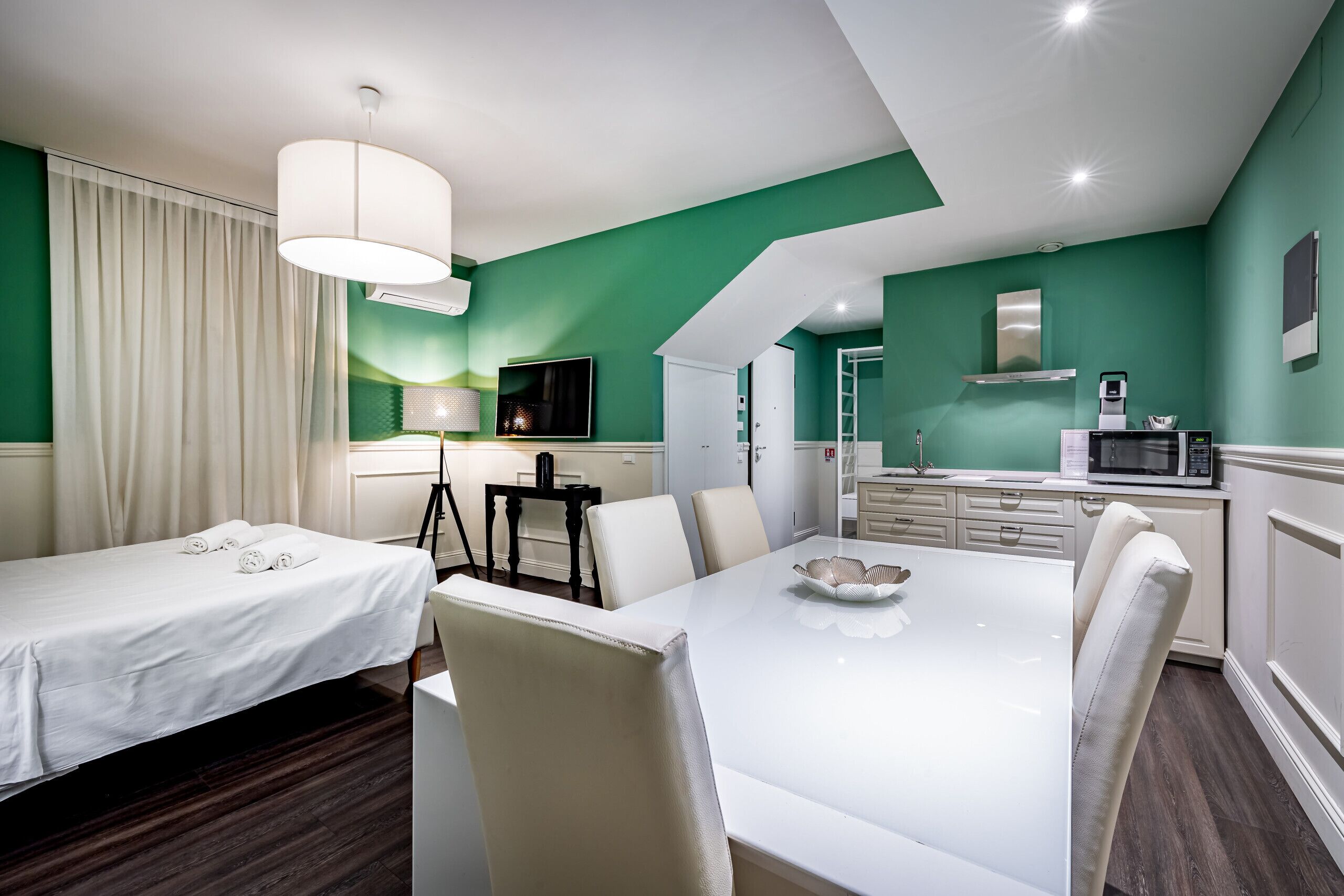 Ein Hotelzimmer mit Essbereich, Küchenzeile und Fernseher.
