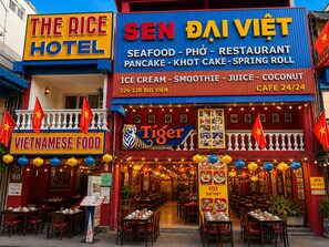 Un restaurante llamado 'SEN DAÏ VIET' con un cartel que anuncia sus ofertas, como mariscos, pho y helado.