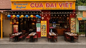 A restaurant named CUA DAI VIET with outdoor seating and a sign indicating it accepts cash and credit cards.