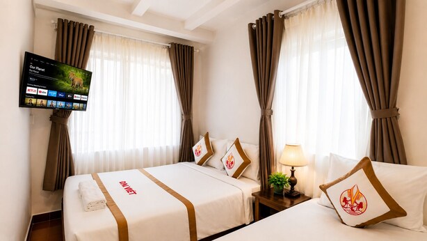 A hotel room with two beds, a TV mounted on the wall, and curtains on the windows. - The Rice Hotel & Tour - 191 Bui Vien (Ho Chi Minh City)