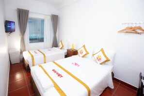 A hotel room with two beds, each with a white bedspread and a golden stripe, a small wooden nightstand, a television mounted on the wall, and a window with curtains. - The Rice Hotel & Tour - 191 Bui Vien (Ho Chi Minh City)