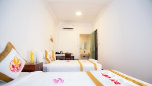 Una habitación de hotel con dos camas, un escritorio y un baño.
