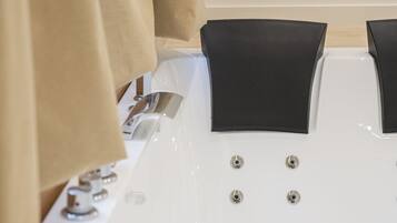 Ein modernes Badezimmer mit einer großen Badewanne, einer Duschkabine und einem WC.