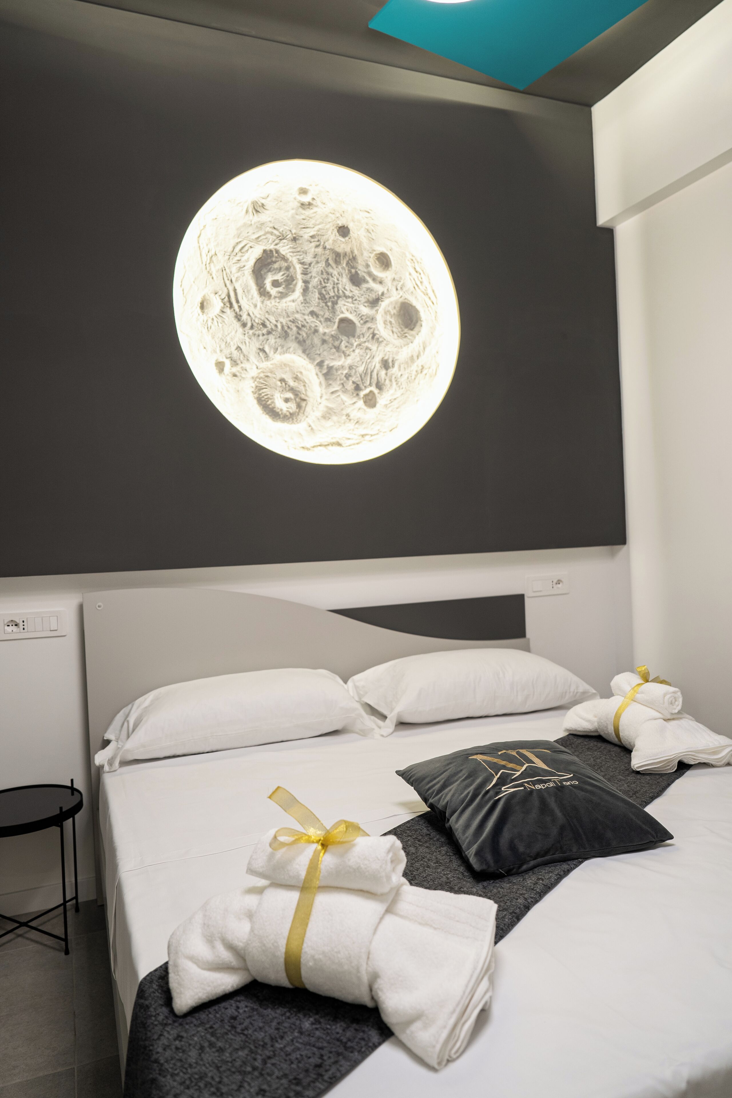 A hotel room with a bed, pillows, and towels.