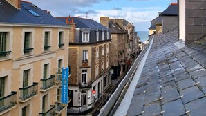 A hotel with a traditional European architectural style, featuring a stone facade, multiple windows, and a visible entrance. - Charming seaside apartment (Dinard)