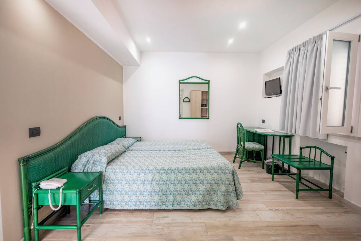 Ein Schlafzimmer mit Bett, Schreibtisch und Stuhl.
