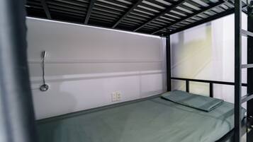 Un lit superposé avec un matelas vert et une structure en métal.