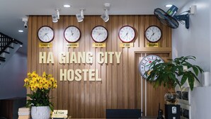 A reception desk with clocks displaying times from London, New York, Ha Noi, Paris, and Beijing. - Ha Giang City Hostel (Ha Giang 1)