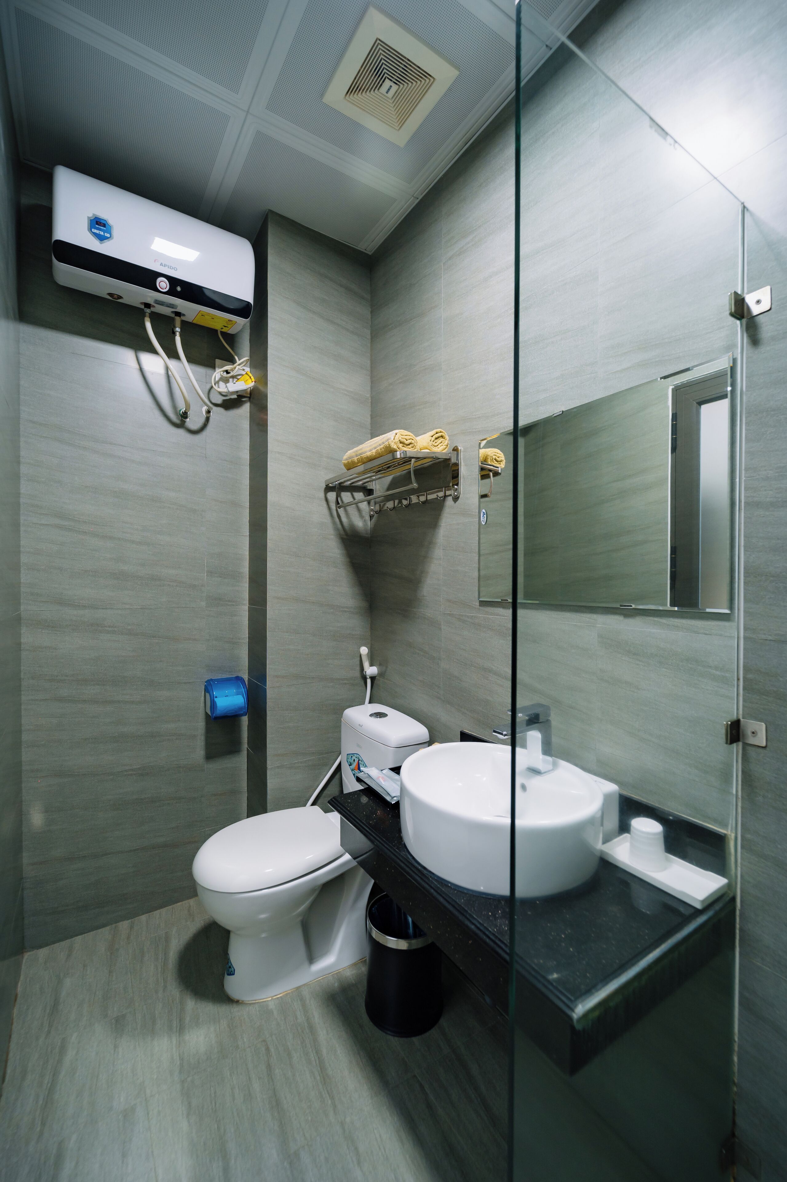 A modern bathroom with a toilet, sink, and towel rack.